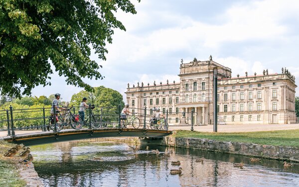 Familie mit Fahrrädern auf einer Brücke vor dem Schloss Ludwigslust, Foto: TMV/Tiemann